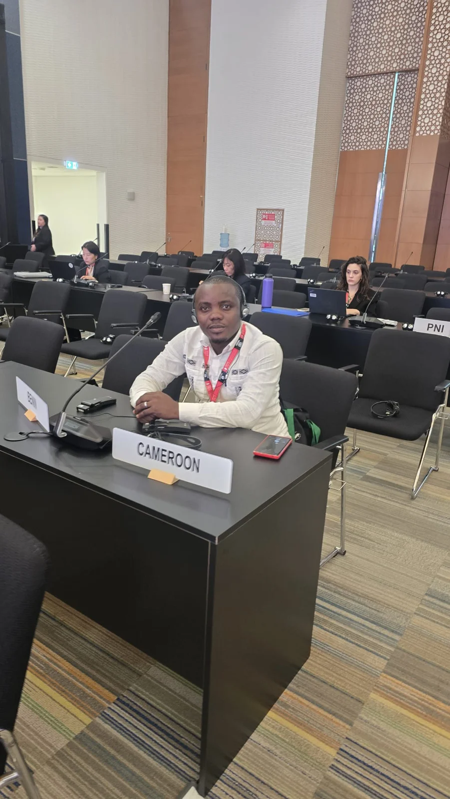 Soglo Éric installé à une table de travail dans une salle de conférence